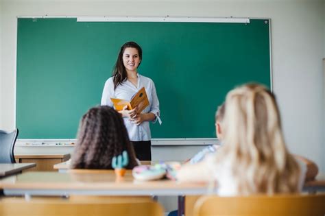 Crianças sentadas em sala de aula com professora | Foto Grátis