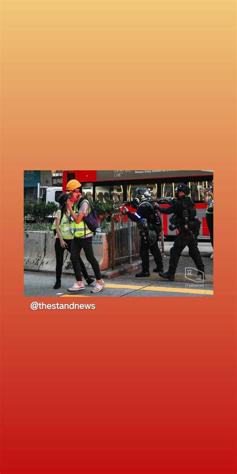 This picture shows that two police riot-controll officers point their gun towards reporters : r ...