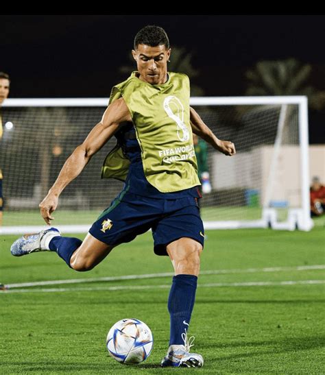 a man kicking a soccer ball on top of a field