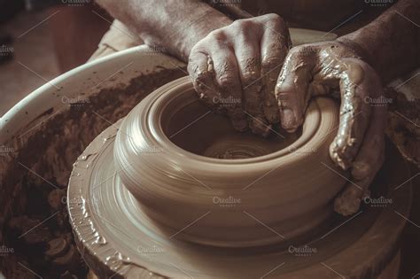 elderly man making pot using pottery wheel in studio. Close-up ...