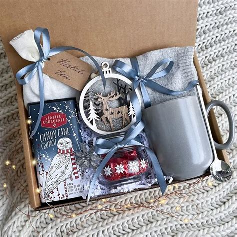 a christmas gift box with an ornament, mug and other items