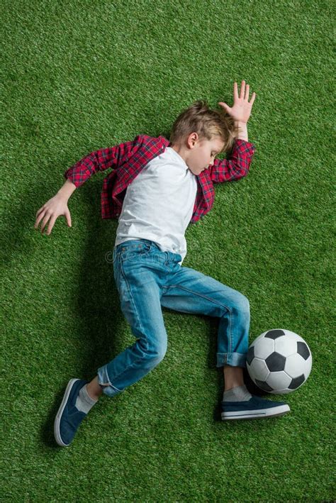 Boy with Soccer Ball Lying on Green Grass Stock Photo - Image of ...