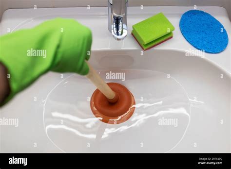 Sink, Clogged drain, unclog with the plunger Stock Photo - Alamy