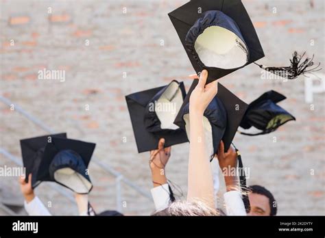 Time to throw those hats in the air. Shot of a group of students throwing their caps into the ...