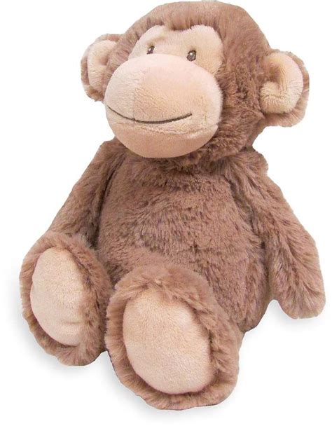 a brown stuffed monkey sitting up against a white background