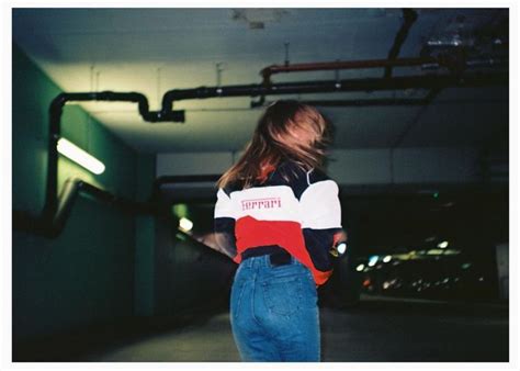 a woman is walking in an empty parking garage with her back to the camera,