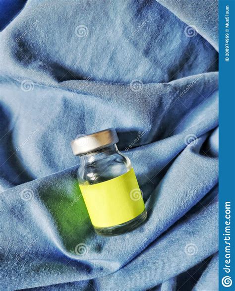 A Yellow Labelled Vaccine Vial on a Blue Cloth for Vaccination Covid-19 ...