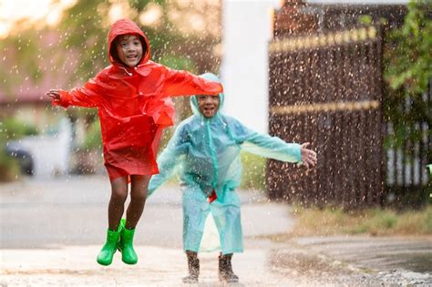 Asian children playing in the rain are happy.they are jumping | Premium Photo