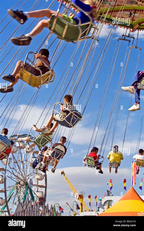 Kids on a Carnival swing ride high above the ground Stock Photo - Alamy