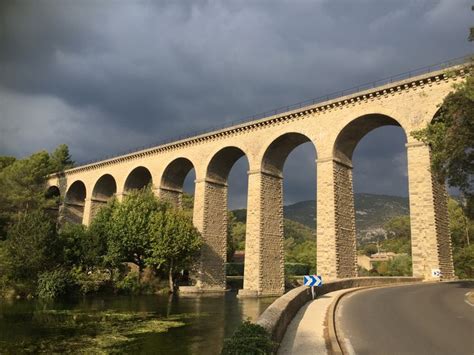 an old stone bridge over a river under a cloudy sky