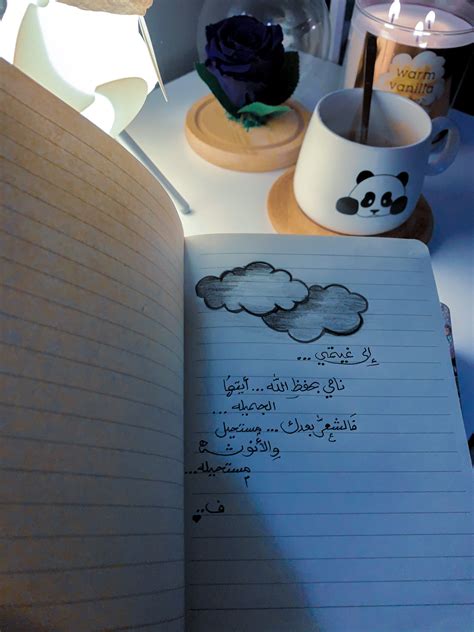an open notebook sitting on top of a desk next to a lamp and cup filled ...