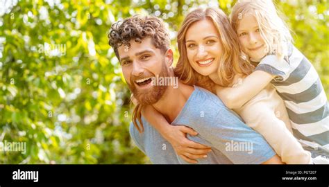 Strong man supporting his family by carrying wife and son Stock Photo ...