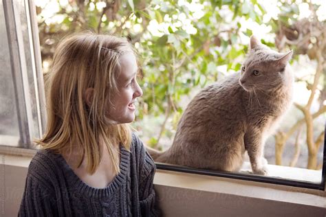 "Girl Next To Window Looking At Gray Cat" by Stocksy Contributor "Dina ...