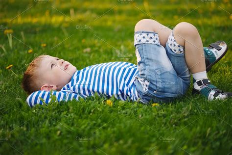 little boy lying on the grass | High-Quality Nature Stock Photos ~ Creative Market