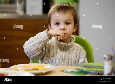 Little toddler boy, eating junk food in restaurant Stock Photo - Alamy