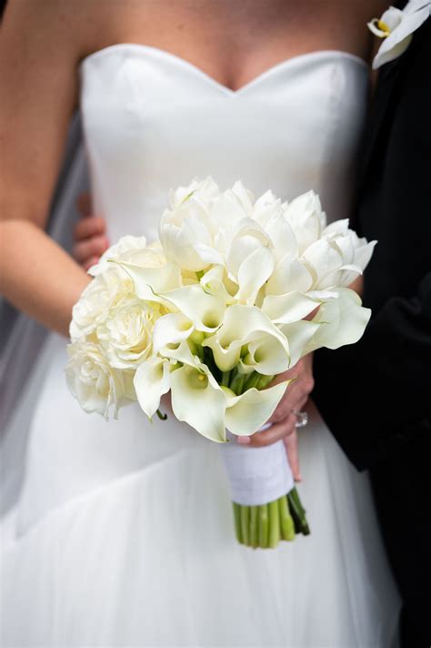 Classic wedding bouquet of white calla lilies, garden roses, and tulips designed by Edge Design ...