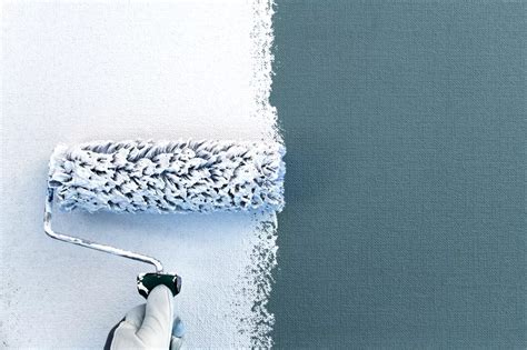 a person using a paint roller to paint a wall with blue and white paint on it