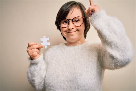 Young Down Syndrome Woman Holding Puzzle Piece As Problem Solution and Cooperation Union ...