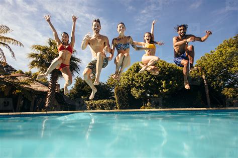 Crazy young people jumping into a pool stock photo (143291) - YouWorkForThem