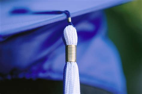 A blue and white tassel on a blue graduation cap ...