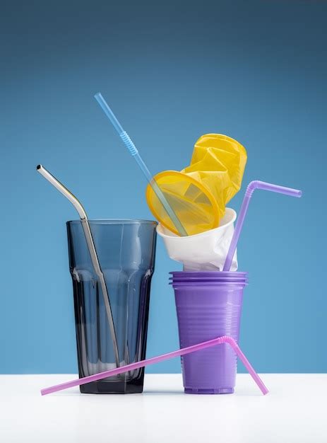 Premium Photo | Plastic and glass glasses with drinking straws. blue background and white ...