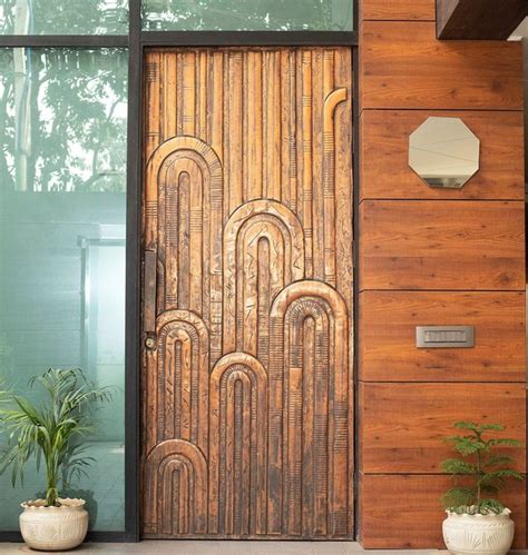 a wooden door sitting next to a plant in front of a window