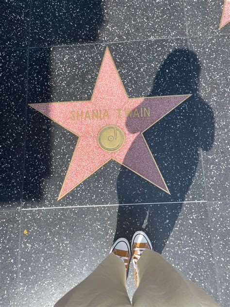 a person standing in front of a star on the hollywood walk of fame with ...