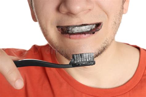 Man Brushing Teeth with Charcoal Toothpaste on White Background ...