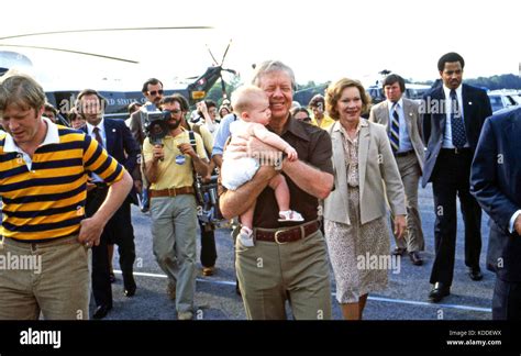 President Jimmy Carter, holds grandchild accompanied by son Jack (left ...