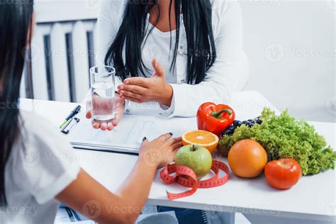 Female nutritionist gives consultation to patient indoors in the office ...