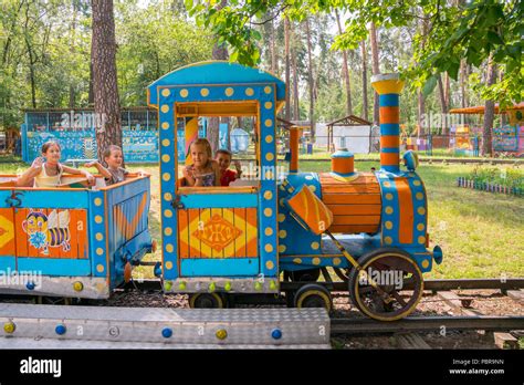 Four little children are riding on a children's train in the park Stock Photo - Alamy