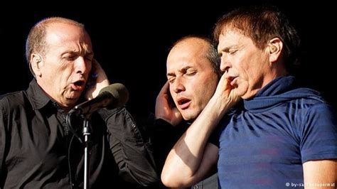 three men standing next to each other in front of a microphone