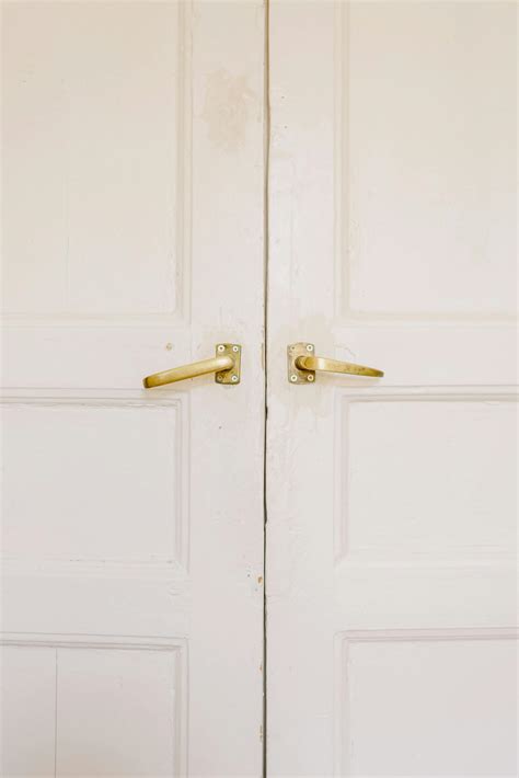 Modern white house doors with golden handles · Free Stock Photo