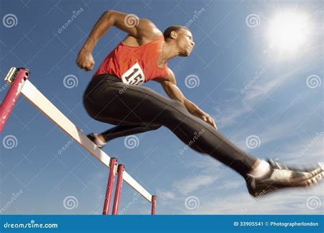 Male Athlete Jumping Over A Hurdles Stock Image - Image: 33905541