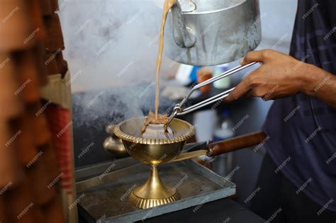 Premium Photo | Masala tea is popularly known in india is being poured in mud cups, kulhad tea ...