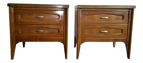 a pair of wooden nightstands with glass top on each side and one drawer in the middle