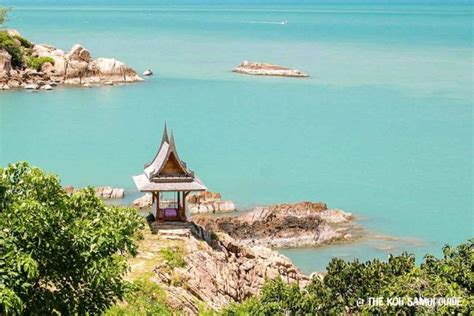 a gazebo sitting on top of a lush green hillside next to the ocean and trees