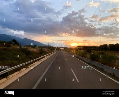 Road view in the evening with a sunset Stock Photo - Alamy