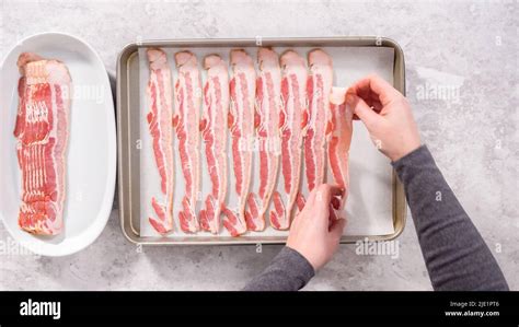 Flat lay. Step by step. Uncooked bacon strips on a baking sheet with white parchment paper Stock ...