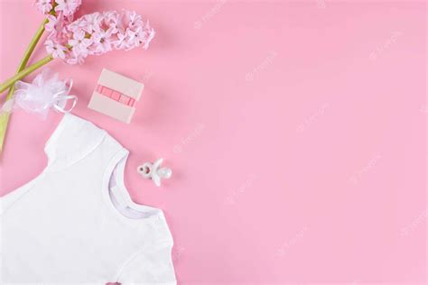 Download A White Baby Bodysuit On Pink Background With Flowers Wallpaper | Wallpapers.com