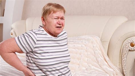 Elderly Woman on Bed with Back Pain Stock Photo - Image of discomfort ...