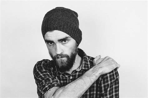 Man in Beanie Holding His Shoulder · Free Stock Photo