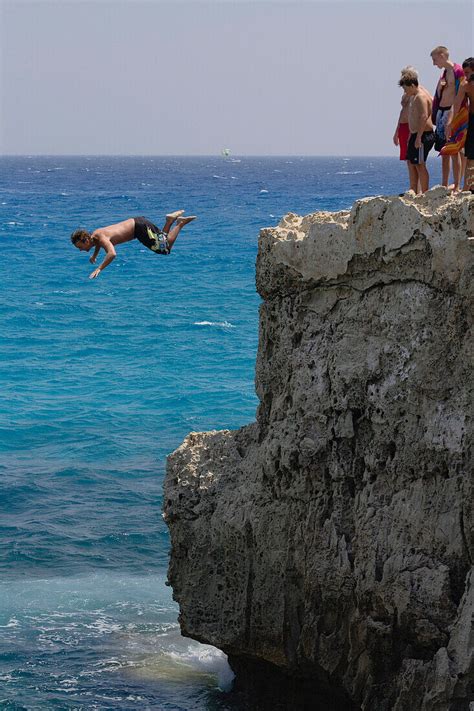 Man cliff jumping, diving from a the … – License image – 70174042 ...