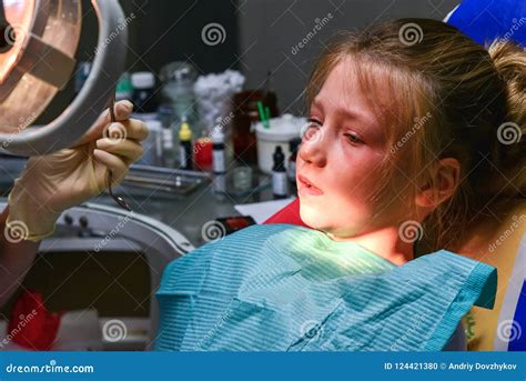 A Little Girl at the Dentist is Crying with Tears at a Doctor`s Appointment while Treating a ...