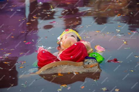 Premium Photo | The idol of the hindu god ganesha immersing in water