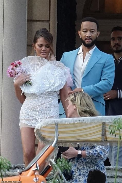 Here comes the bride (again)! Chrissy Teigen stuns in white mini dress as she sweetly kisses ...