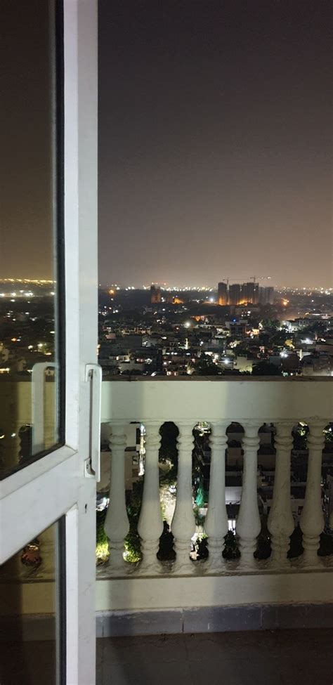 an open door on top of a balcony overlooking a city at night with ...