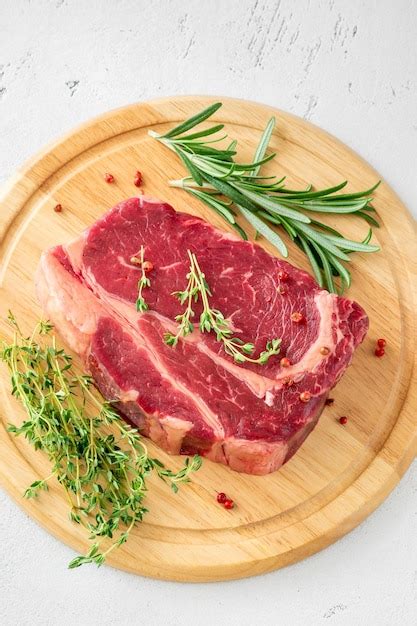 Premium Photo | Raw rib eye beef steak with thyme and rosemary