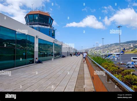 Passengers outside watching the runway planes at Madeira Airport ...