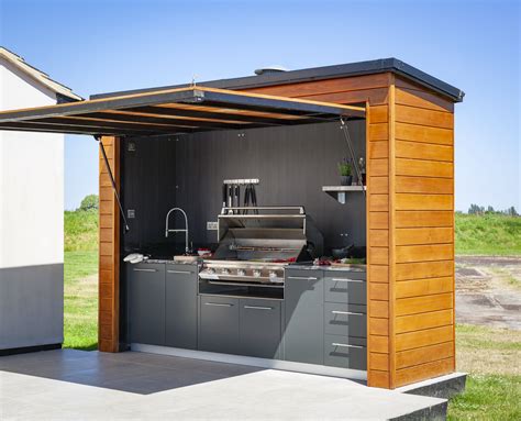 an outdoor kitchen is built into the side of a house with a grill and sink